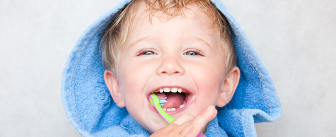 child brushing teeth with manual toothbrush